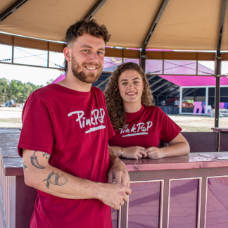 Man en vrouw met bordeaux rood shirt met wittePinkpop-opdruk op borst