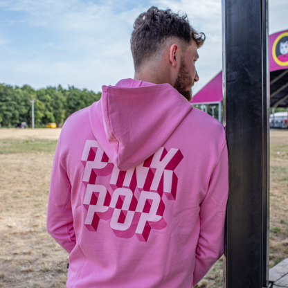 Man met roze hoodie aan - groot logo met letters PINKPOP op rug.
