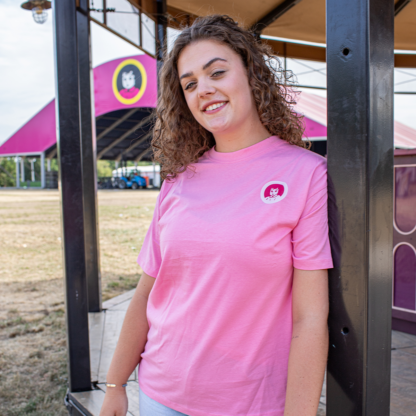 Vrouw met roze shirt aan rond logo op linkerborst