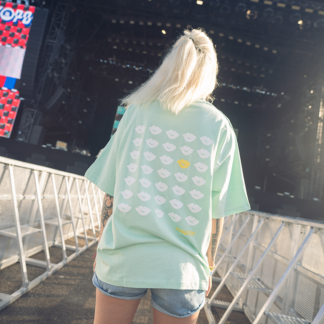 Vrouw met groen shirt, opdruk met wit en geel op rug.
