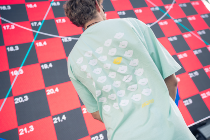 Man met groen shirt, opdruk met wit en geel op rug.