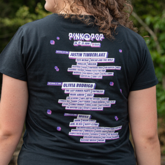 Vrouw met line-up shirt. Artiesten uit line-up Pinkpop 2025 achter op rug gedrukt