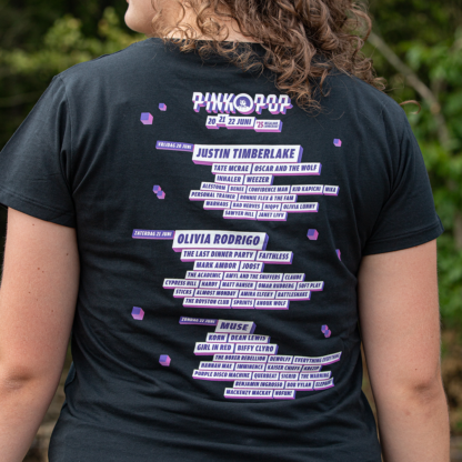 Vrouw met line-up shirt. Artiesten uit line-up Pinkpop 2025 achter op rug gedrukt